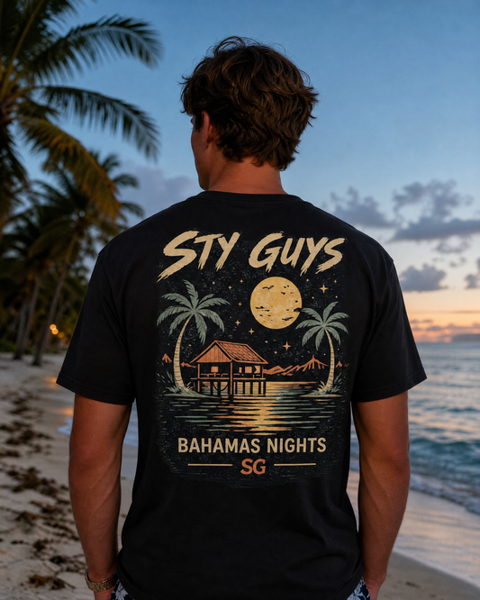 Man wearing the Bahamas Nights tee, Beach colorway, moonlit stilt house back print